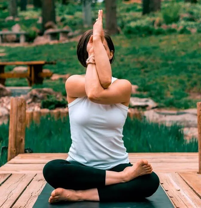 Person crossing the forearms in eagle pose arm position to open the upper back